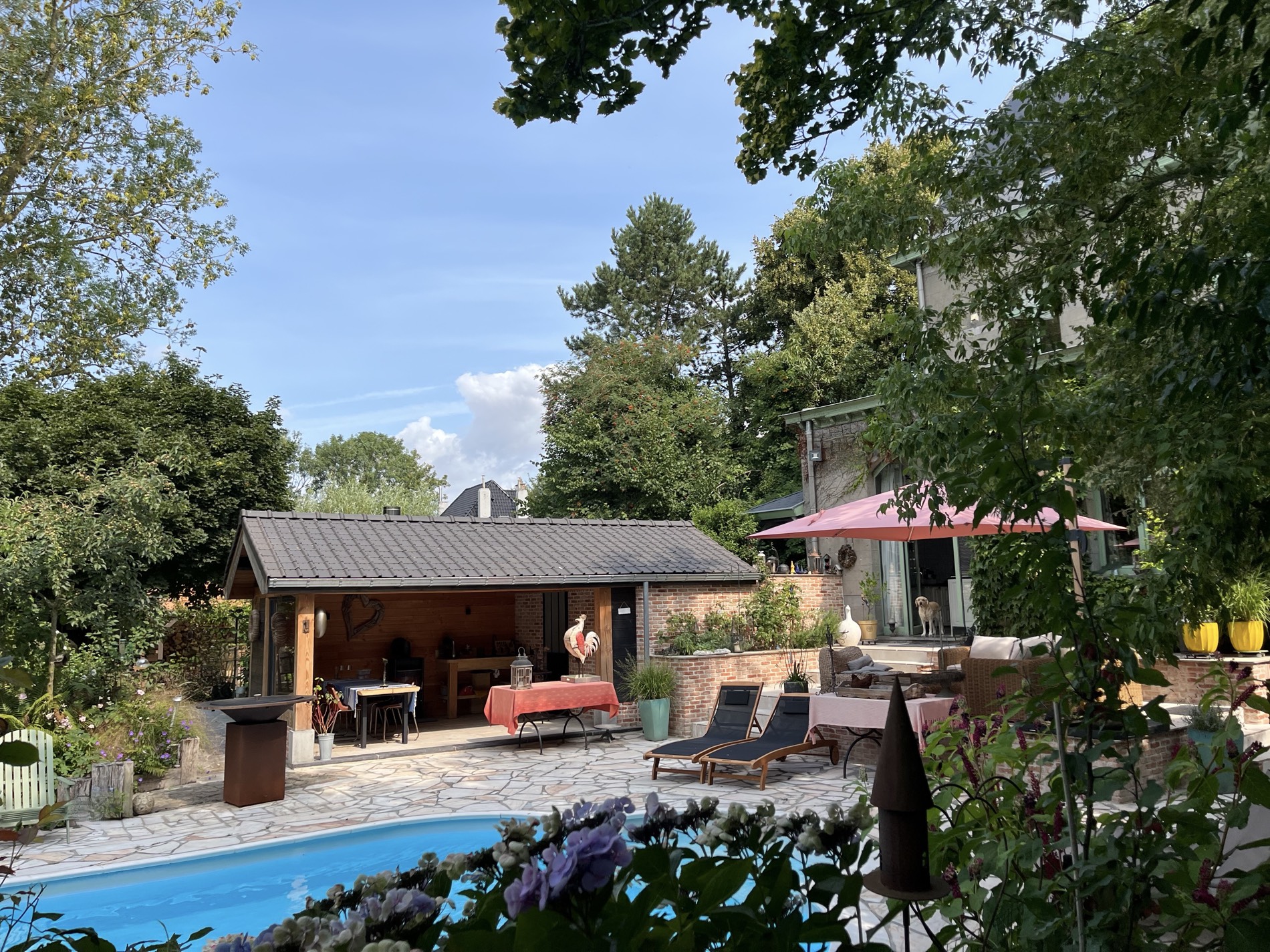 La piscine, la cuisine d'été et la maison de maître de La Roseraie, un soir de juillet